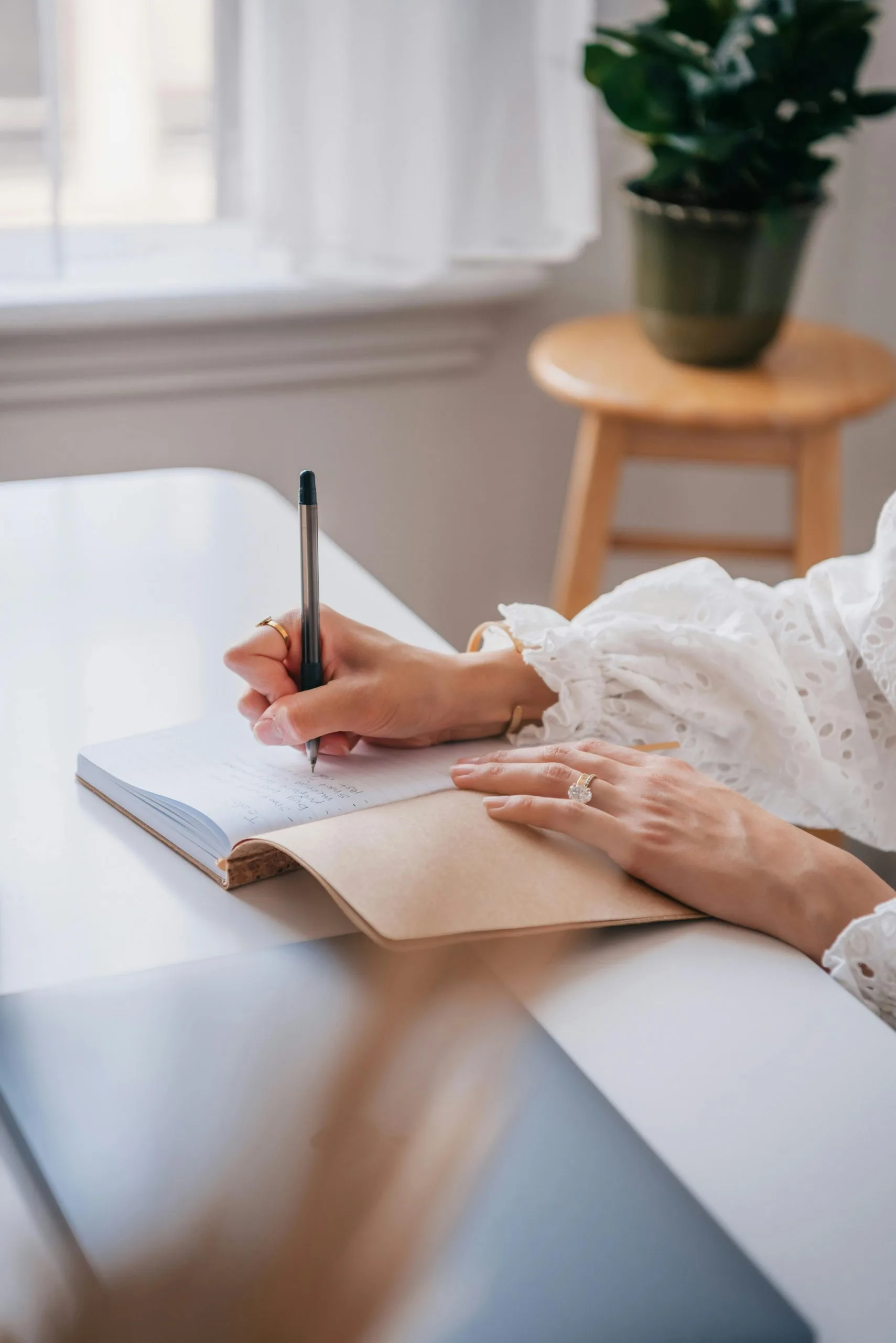 Person schreibt in ein Notizbuch an einem hellen Schreibtisch – Symbol für Selbstreflexion, Journaling, persönliche Entwicklung und achtsame Veränderungsprozesse, vor allem im Bereich der Paarberatung und gemeinsamen Stärkung der Beziehung.