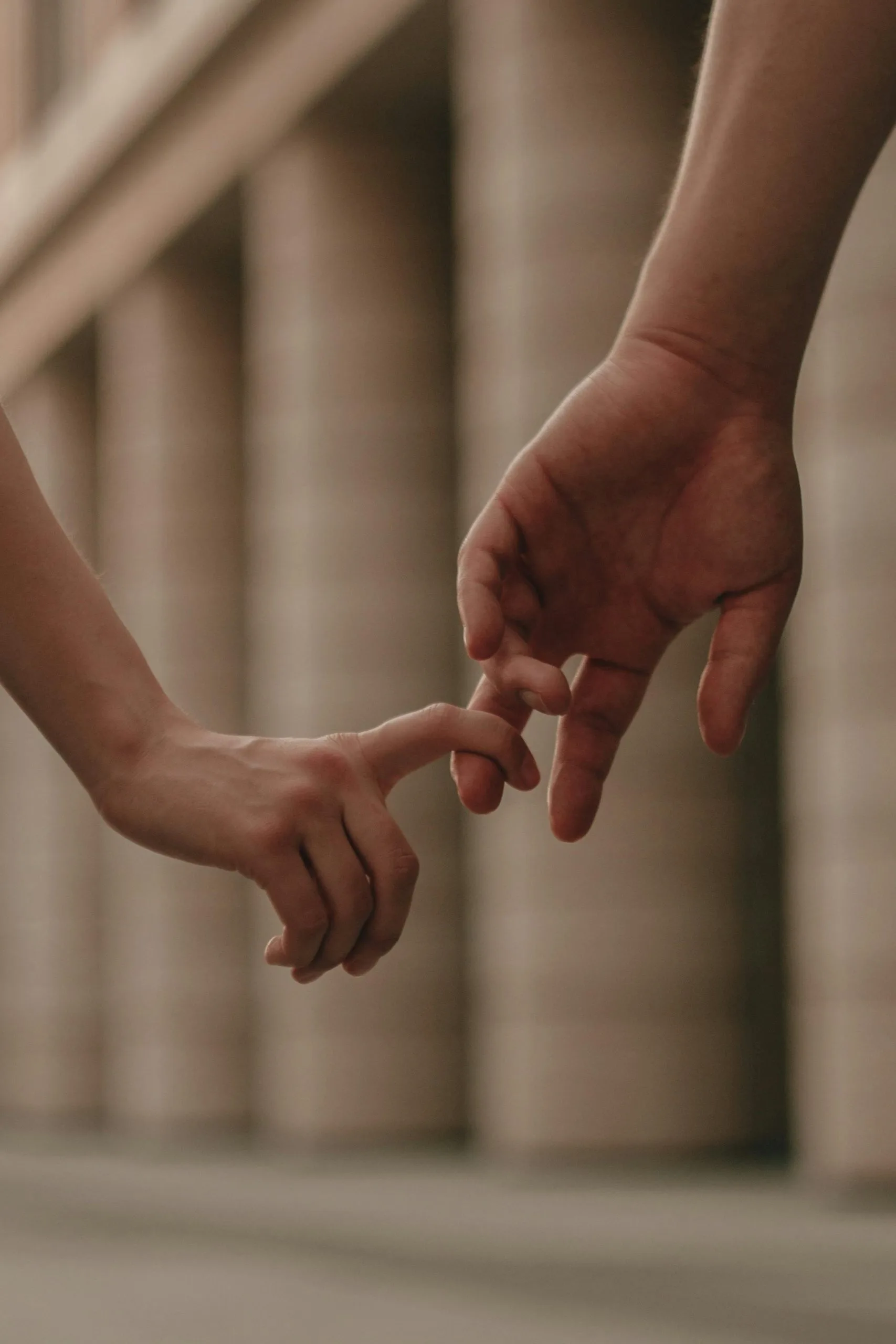 Zwei Hände berühren sich mit den Fingerspitzen – Symbol für Vertrauen, emotionale Nähe, Verbundenheit und den Aufbau einer sicheren Beziehung.